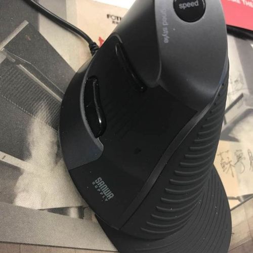 Black wired mouse resting on white desk