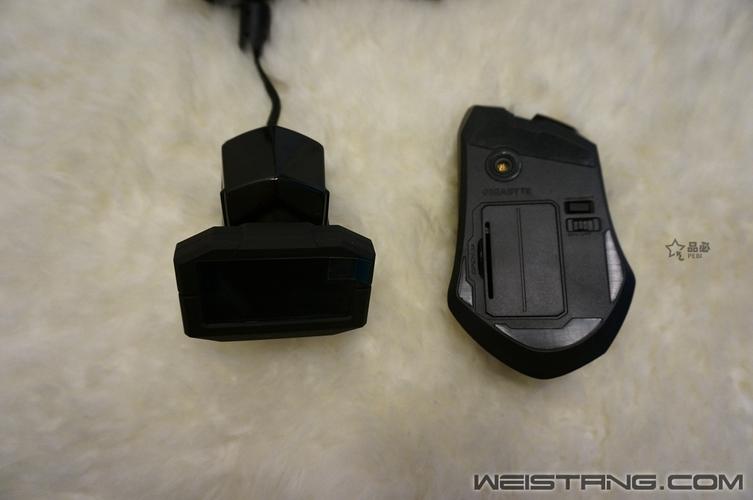 Black mouse on desk with charging cable