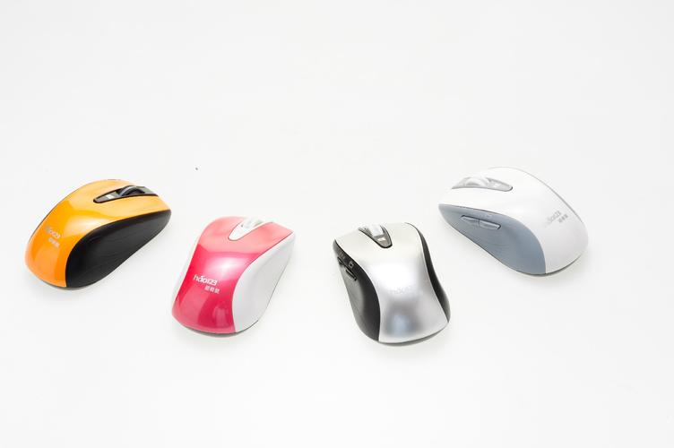 A person's hand choosing between two different computer mice on a desk.
