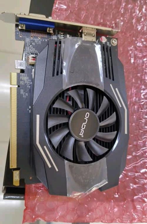 电脑屏幕上显示游戏画面，旁边放着显卡，象征性能测试