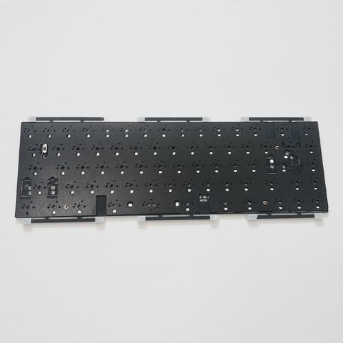 A person choosing between different keyboards on a table